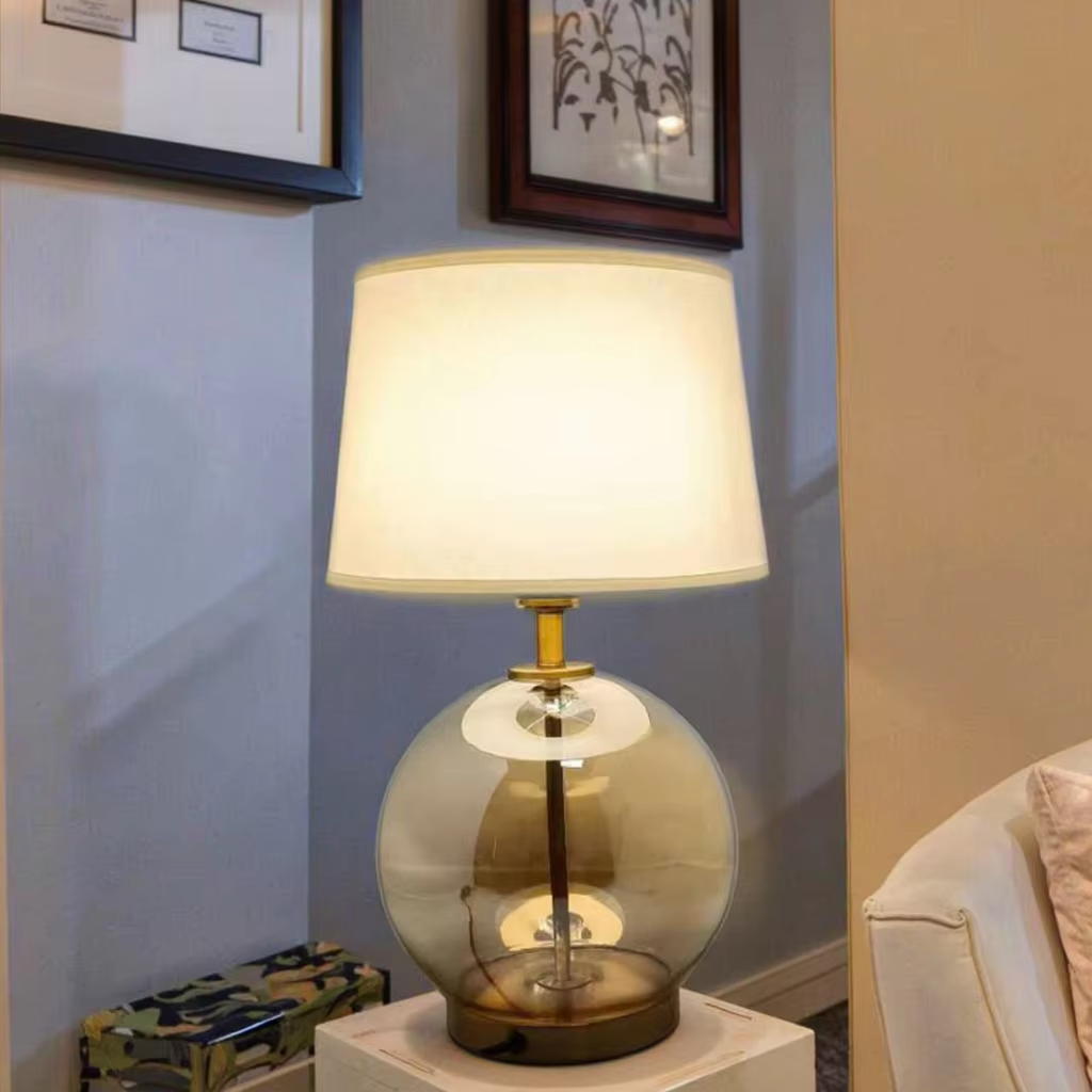 Elevate Spaces with Amber Glass Globe Table Lamp: Gold Metal Base & White Fabric Shade
