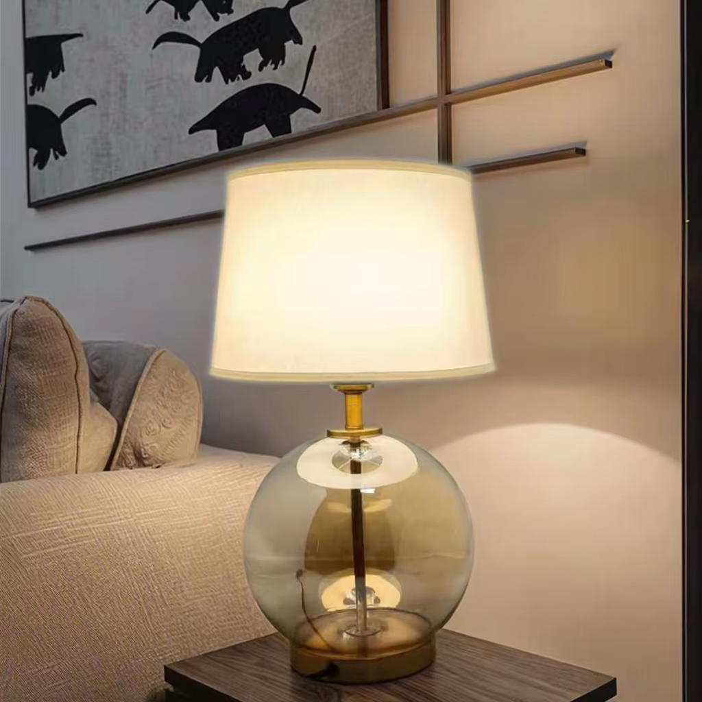Elevate Spaces with Amber Glass Globe Table Lamp: Gold Metal Base & White Fabric Shade