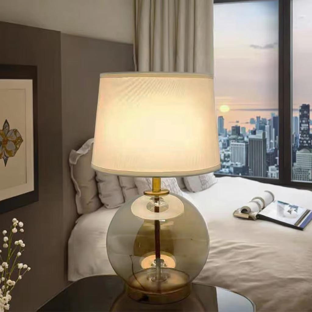 Elevate Spaces with Amber Glass Globe Table Lamp: Gold Metal Base & White Fabric Shade